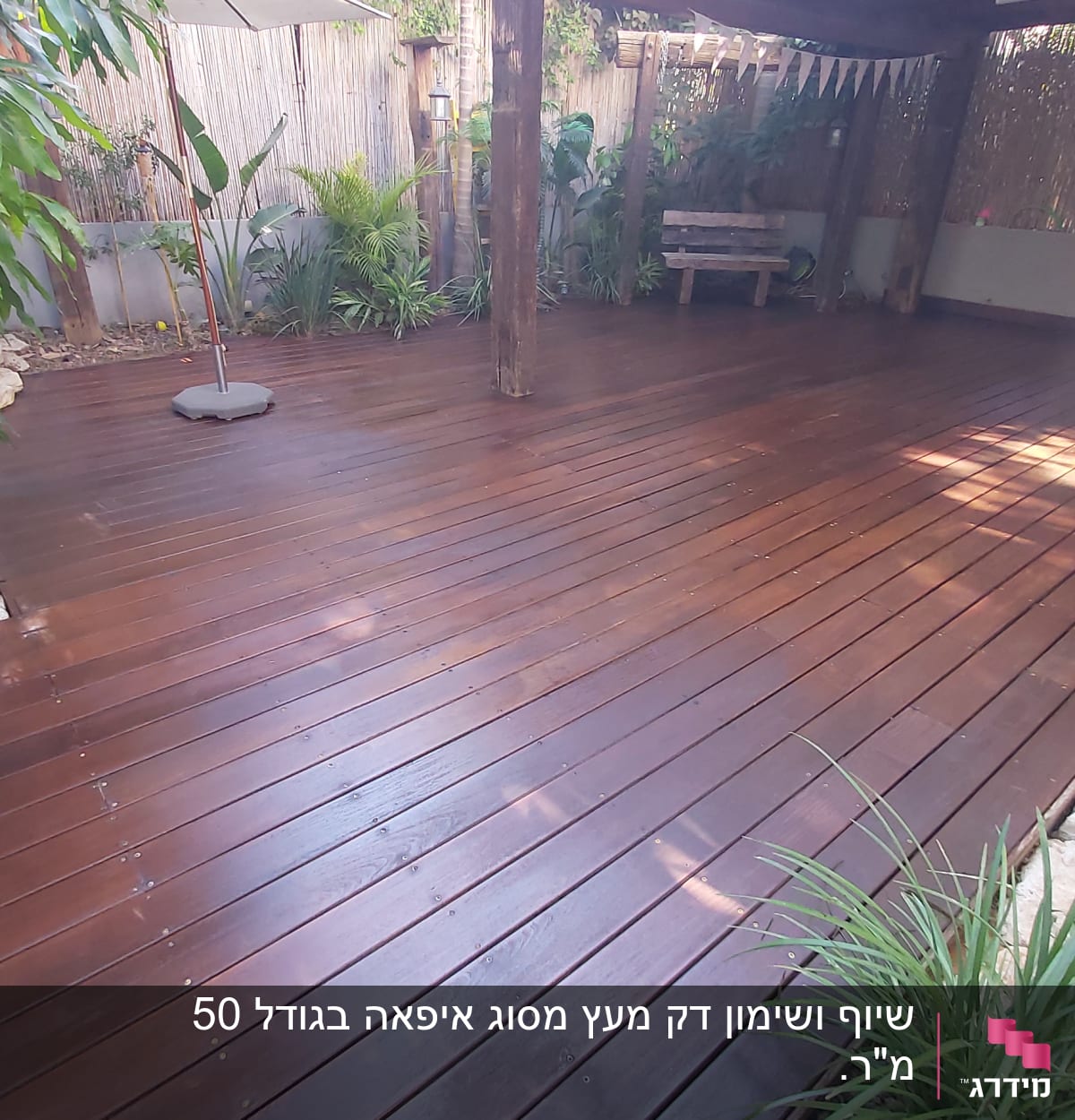 דק עץ בגינה עם צמחייה מסביב ועמוד עץ